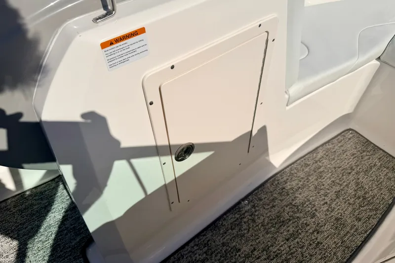 Slide: The Image of 2017 Chaparral 19 Sport H2O boat interior with storage compartment and warning label. - 68