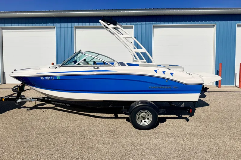 Slide: The Image of 2017 Chaparral 19 Sport H2O boat in blue and white, parked on a trailer. - 5