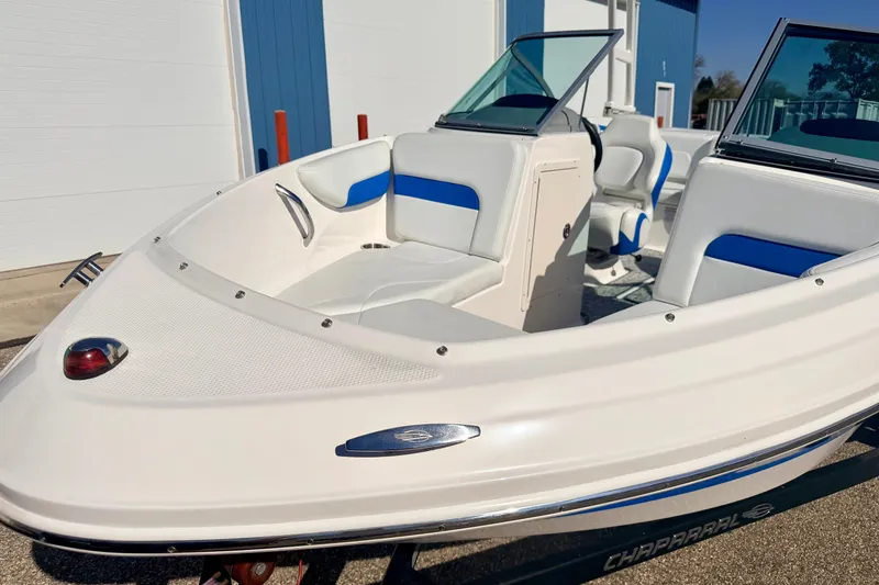 Slide: The Image of 2017 Chaparral 19 Sport H2O boat with blue and white interior, parked outdoors. - 13