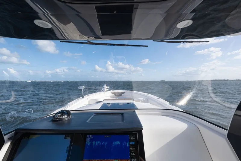 Slide: The Image of Cockpit view from a 2020 Edgewater 370CC boat navigating on open water. - 29