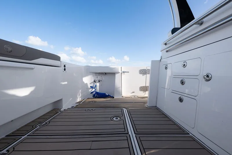Slide: The Image of 2020 Edgewater 370CC boat deck with storage compartments and blue sky background. - 56