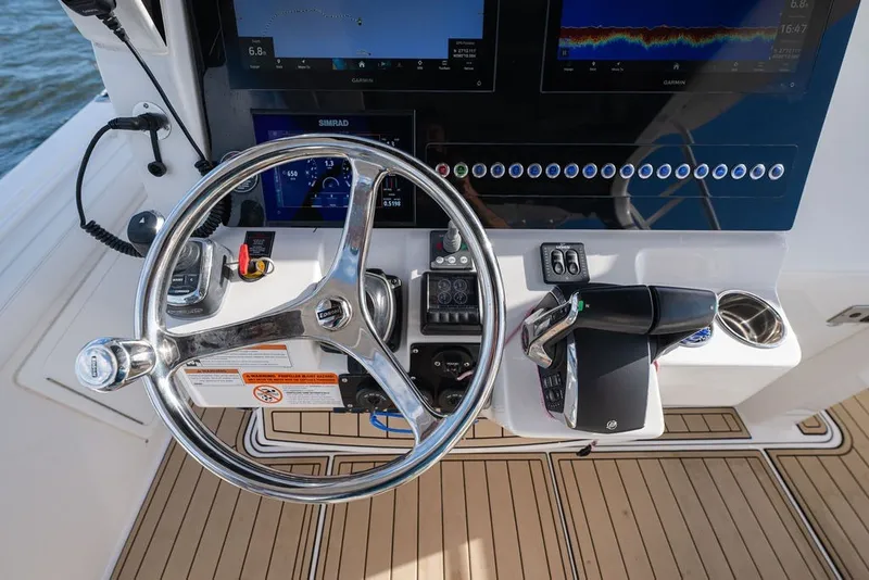 Slide: The Image of Steering console of 2020 Edgewater 370CC boat with modern controls and navigation screens. - 31