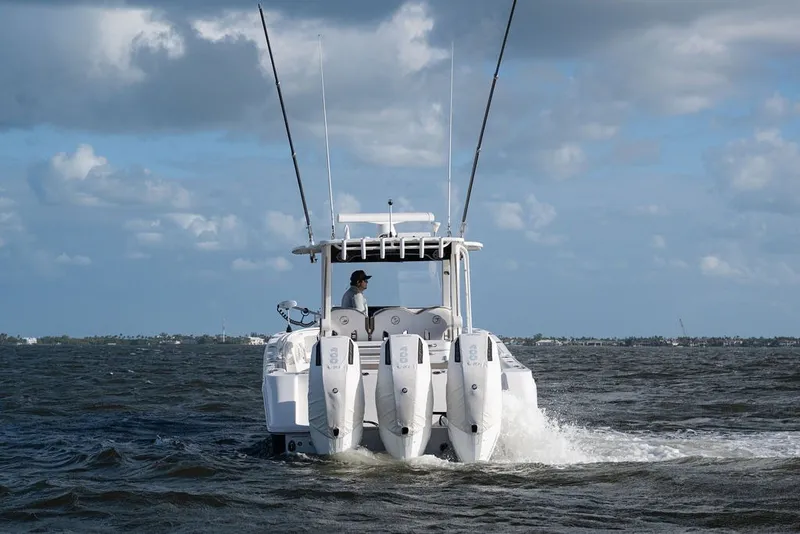 Slide: The Image of 2020 Edgewater 370CC boat cruising on open water under cloudy skies. - 12