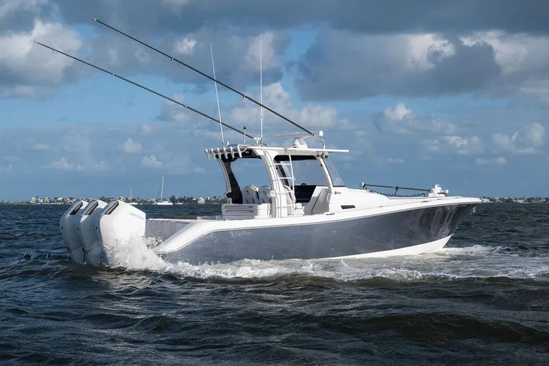 Slide: The Image of 2020 Edgewater 370CC boat cruising on open water under a cloudy sky. - 13