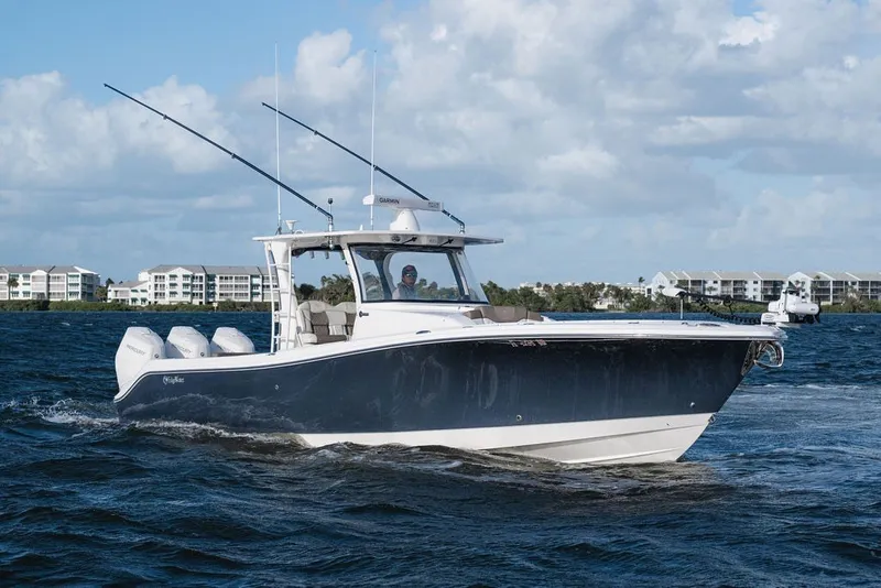 Slide: The Image of 2020 Edgewater 370CC boat cruising on water with buildings in the background. - 4