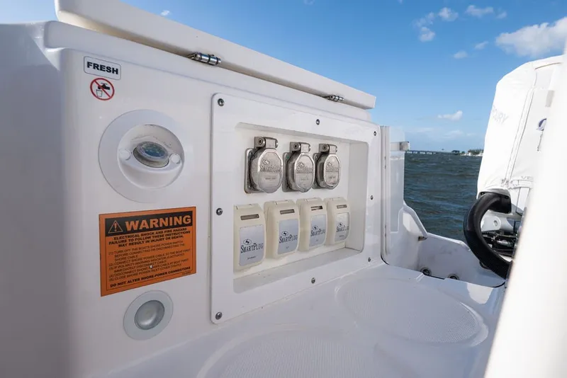 Slide: The Image of 2020 Edgewater 370CC boat electrical panel with warning label and SmartPlug connectors. - 24