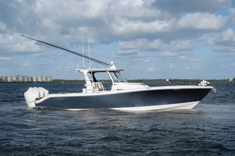 Slide: The Image of 2020 Edgewater 370CC boat cruising on open water under a cloudy sky. - 1