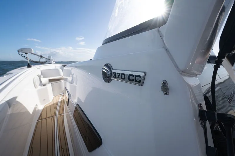 Slide: The Image of Edgewater 370CC 2020 boat on water, sunlit deck, clear sky background. - 55
