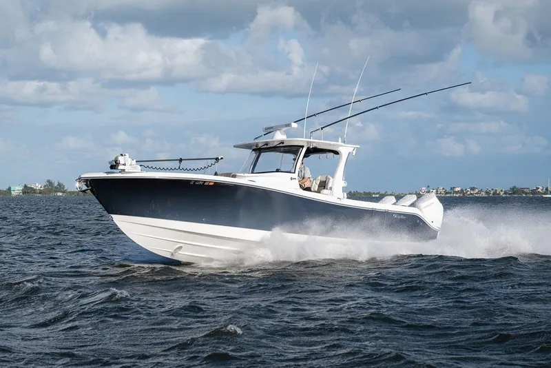 Slide: The Image of 2020 Edgewater 370CC boat cruising on open water under a cloudy sky. - 9