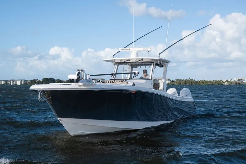 Slide: The Image of 2020 Edgewater 370CC boat cruising on a sunny day with clear skies. - 2