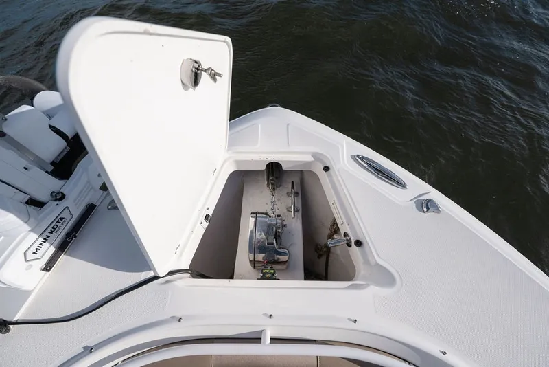 Slide: The Image of Open anchor compartment on 2020 Edgewater 370CC boat, featuring Minn Kota equipment. - 49
