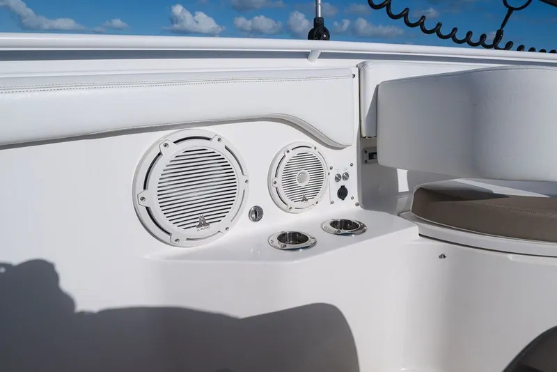 Slide: The Image of 2020 Edgewater 370CC boat interior with speakers and cup holders under a blue sky. - 58