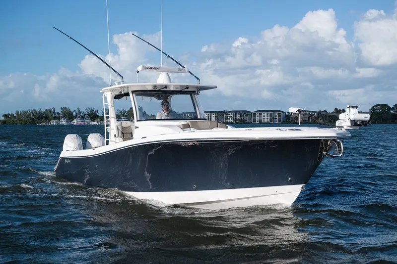 Slide: The Image of 2020 Edgewater 370CC boat cruising on a sunny day with clear skies. - 7