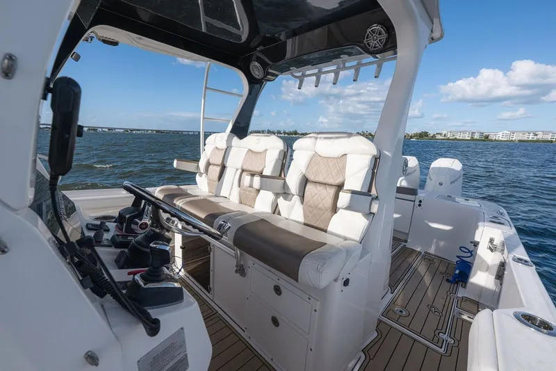 Slide: The Image of 2020 Edgewater 370CC boat interior with luxurious seating and modern controls on open water. - 19
