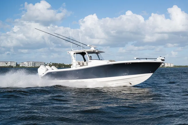 The Image of 2020 Edgewater 370CC boat cruising on open water under a blue sky. - 0
