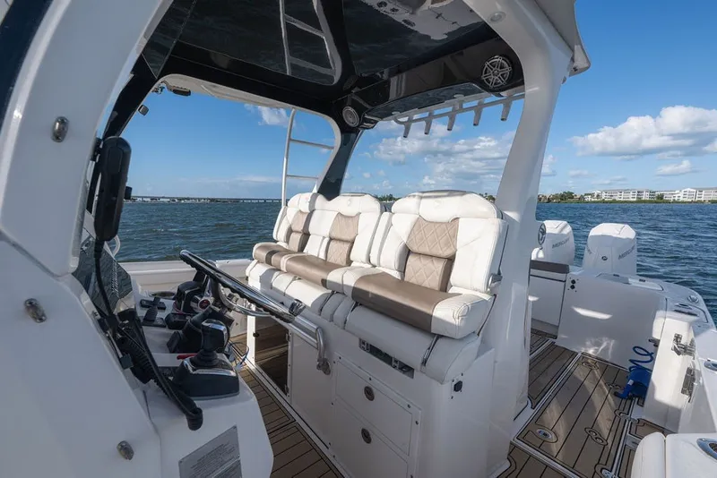 Slide: The Image of 2020 Edgewater 370CC boat interior with luxurious seating and modern controls on open water. - 20