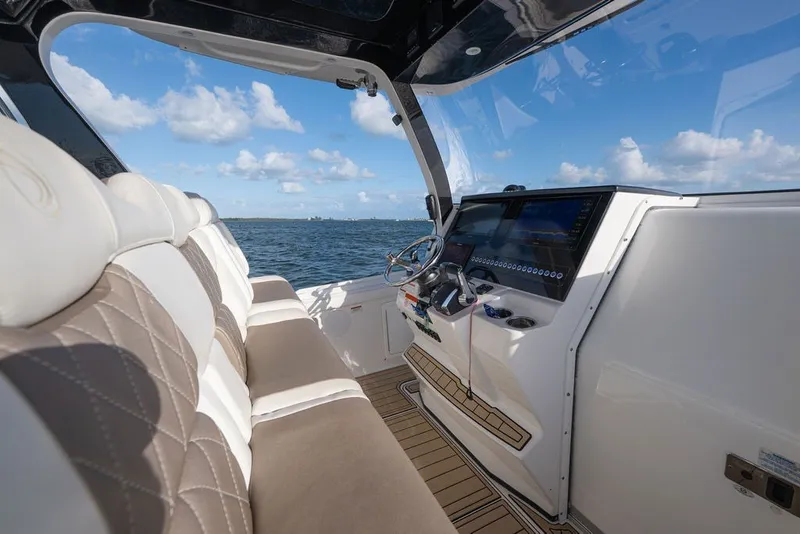 Slide: The Image of Interior view of 2020 Edgewater 370CC boat with luxurious seating and modern dashboard. - 17