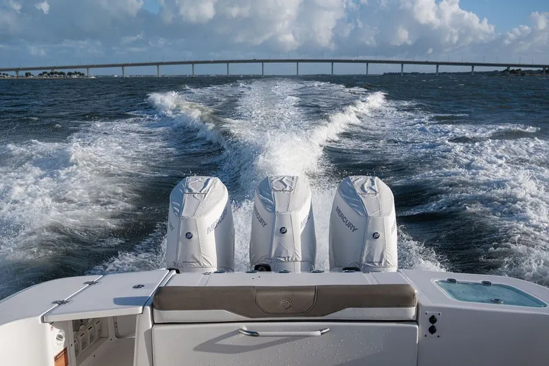 Slide: The Image of 2020 Edgewater 370CC boat with triple Mercury engines cruising on open water. - 14