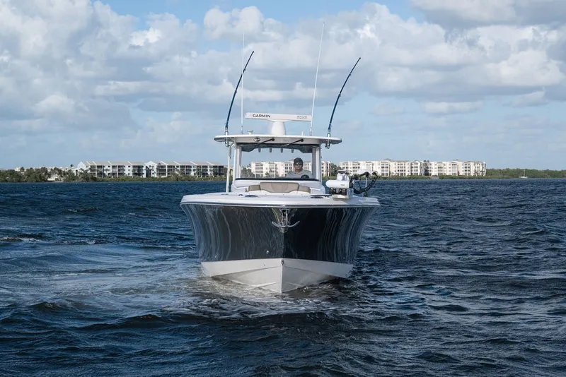 Slide: The Image of 2020 Edgewater 370CC boat cruising on open water under a partly cloudy sky. - 3