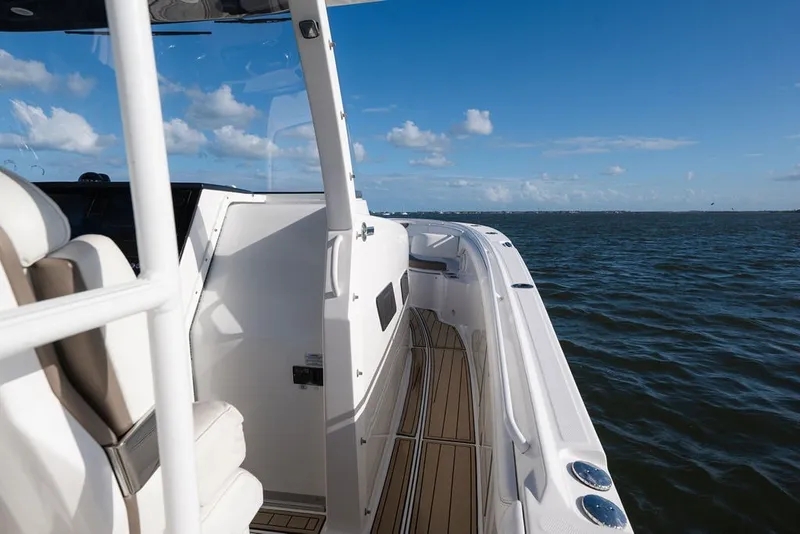 Slide: The Image of 2020 Edgewater 370CC boat cruising on open water under a clear blue sky. - 57