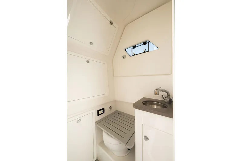 Slide: The Image of Interior of 2020 Edgewater 370CC boat bathroom with sink and storage cabinets. - 68