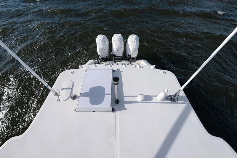 Slide: The Image of 2020 Edgewater 370CC boat with triple outboard motors on open water. - 25