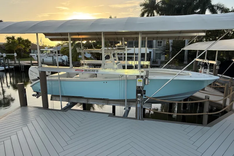 The Image of 2014 Yellowfin 32 Offshore boat docked at sunset, featuring a sleek design and light blue hull. - 0