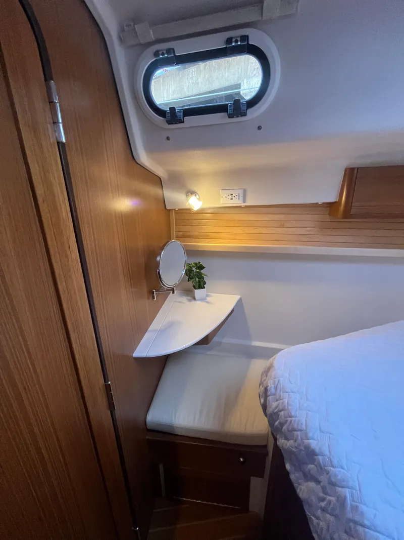 Slide: The Image of Cozy cabin interior of 2025 Catalina 386 sailboat with wooden accents and porthole window. - 14