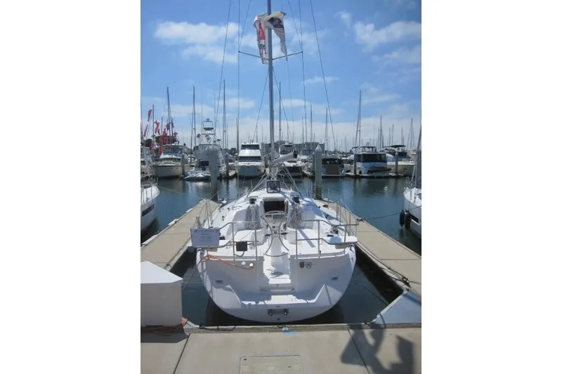Slide: The Image of Een witte zeilboot aangemeerd in een drukke jachthaven met andere boten eromheen. - 36