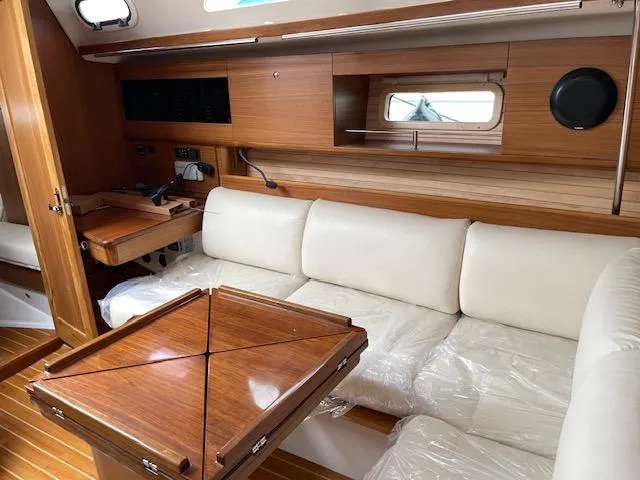 Slide: The Image of Luxurious interior of 2025 Catalina 386 yacht with white seating and wooden table. - 2