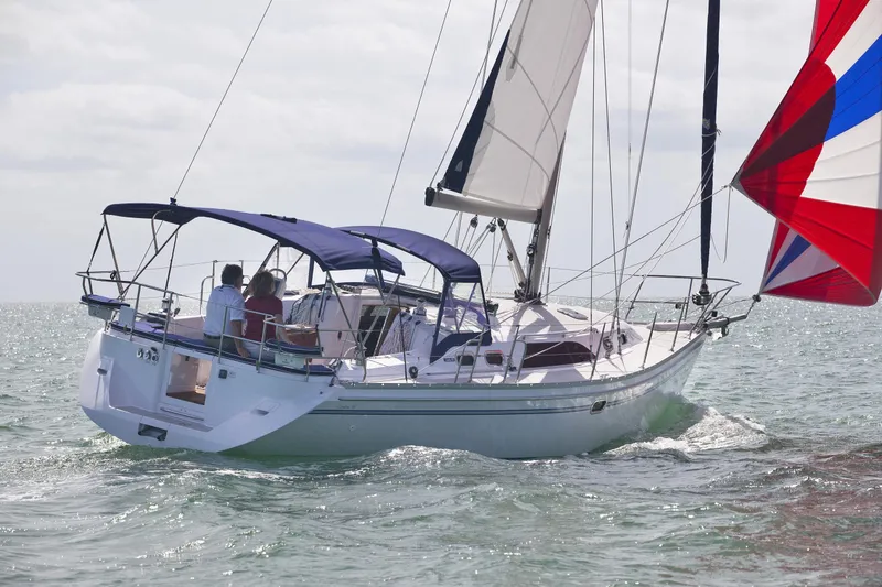 Slide: The Image of 2025 Catalina 386 sailboat navigating open waters with colorful sails. - 54