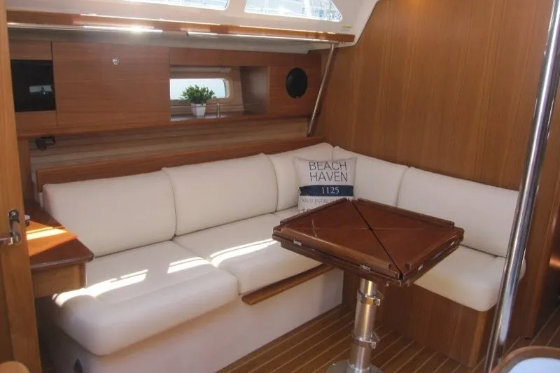 Slide: The Image of Interior of 2025 Catalina 386 yacht with white seating and wooden table. - 23