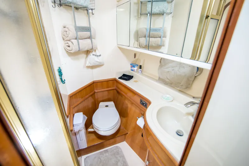Slide: The Image of Compact bathroom in a 2000 Johnson 58 yacht with toilet, sink, and storage. - 15