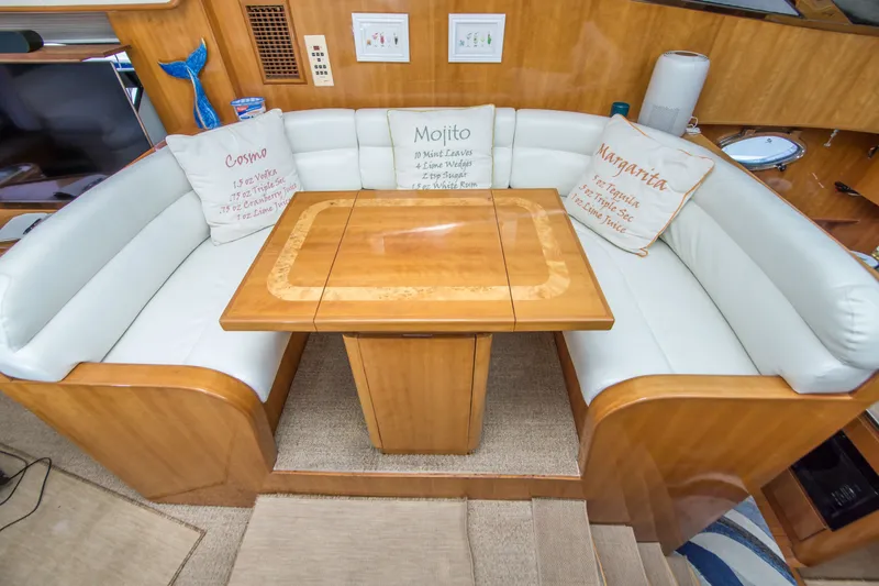 Slide: The Image of Luxurious Johnson 58 yacht interior with cushioned seating and wooden table, 2000 model. - 25