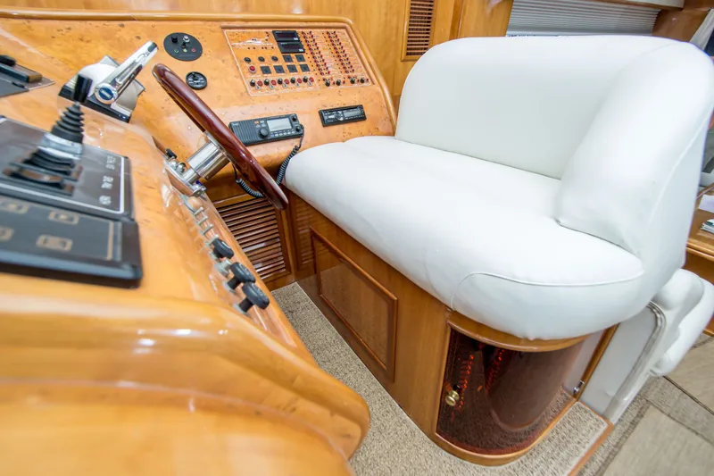 Slide: The Image of Luxurious helm station of a 2000 Johnson 58 yacht with white seating and wooden controls. - 23