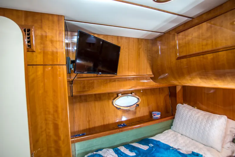 Slide: The Image of Luxurious cabin interior of 2000 Johnson 58 yacht with wood paneling and mounted TV. - 17