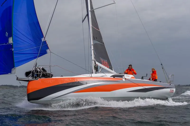 Slide: The Image of 2025 Jeanneau Sun Fast 3300 sailing with vibrant orange and blue sails. - 27