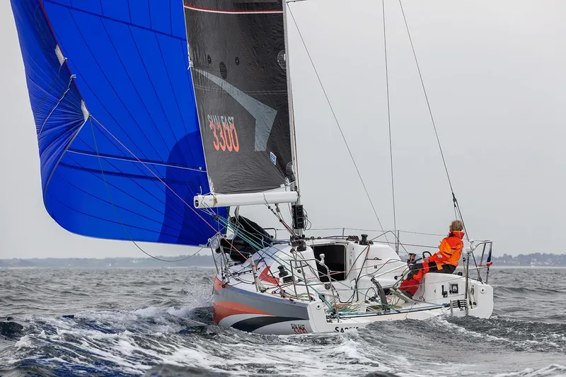 Slide: The Image of 2025 Jeanneau Sun Fast 3300 sailing with vibrant blue spinnaker on open water. - 15