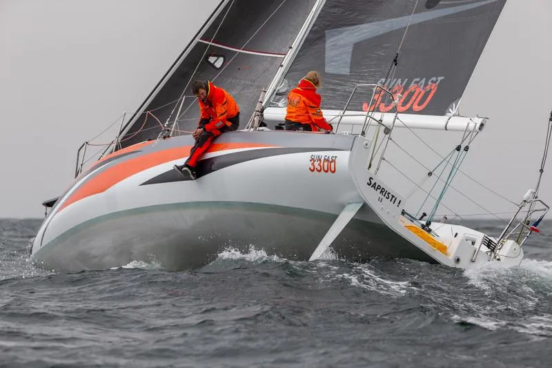 Slide: The Image of 2025 Jeanneau Sun Fast 3300 sailing in rough seas, crew in orange gear. - 45