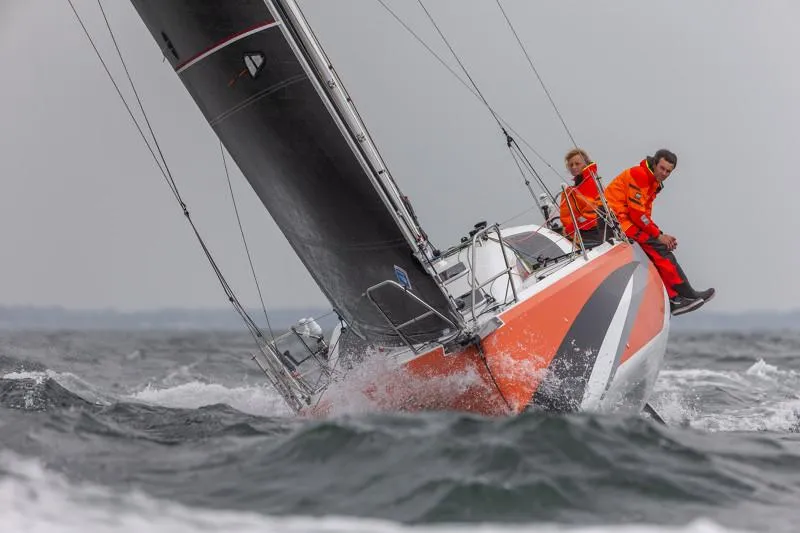Slide: The Image of 2025 Jeanneau Sun Fast 3300 sailing in rough seas with crew in orange gear. - 44