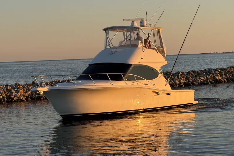 Slide: The Image of 2017 Tiara Yachts 39 Convertible cruising on calm waters at sunset. - 9