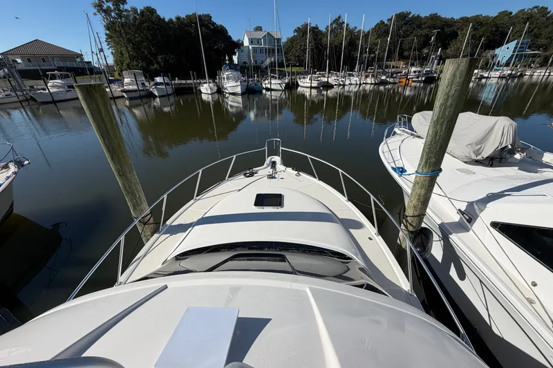 Slide: The Image of 2017 Tiara Yachts 39 Convertible docked in a marina with surrounding boats. - 35