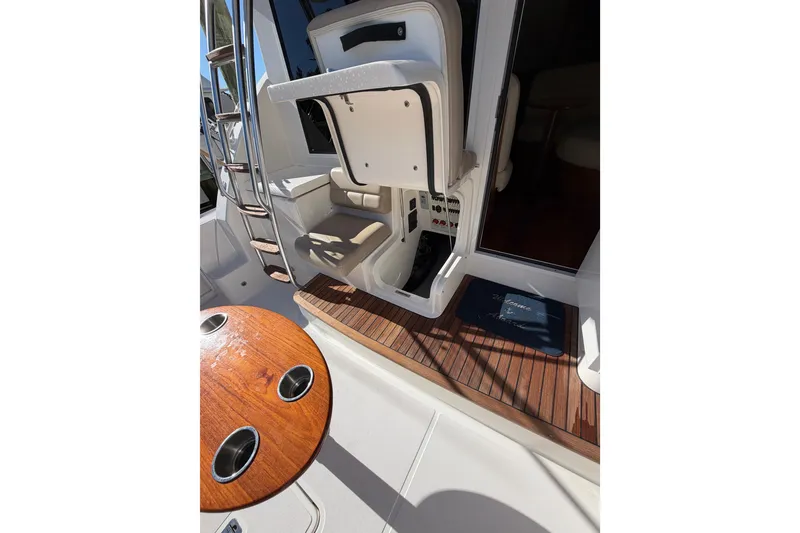 Slide: The Image of 2017 Tiara Yachts 39 Convertible cockpit with wooden table and ladder. - 20