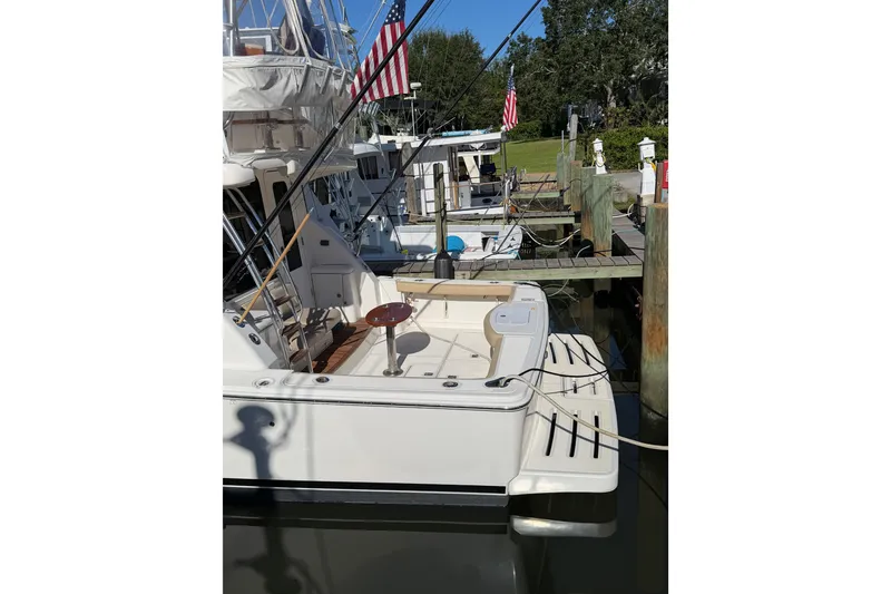 Slide: The Image of 2017 Tiara Yachts 39 Convertible docked, featuring spacious deck and American flag. - 16