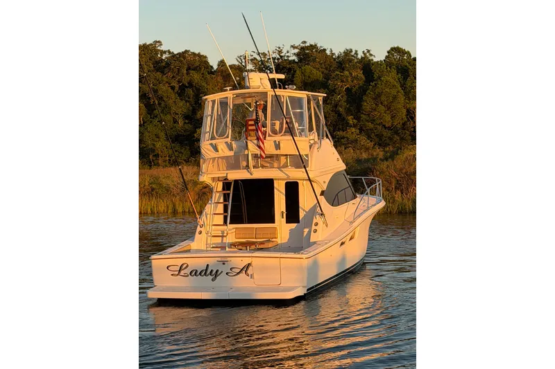 Slide: The Image of 2017 Tiara Yachts 39 Convertible boat on calm water at sunset. - 12