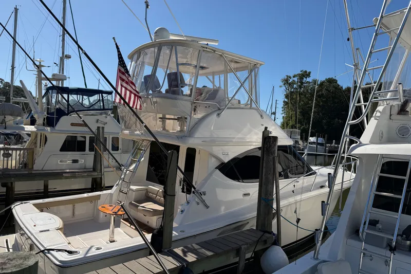 Slide: The Image of 2017 Tiara Yachts 39 Convertible docked at marina with American flag. - 15