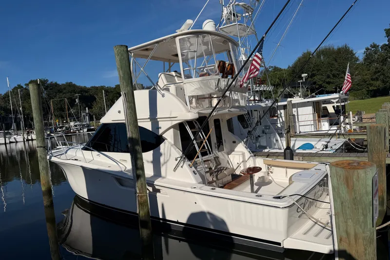 Slide: The Image of 2017 Tiara Yachts 39 Convertible docked at marina, sunny day, American flags displayed. - 57