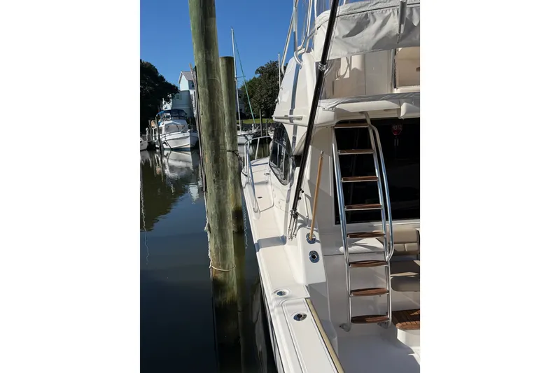 Slide: The Image of 2017 Tiara Yachts 39 Convertible docked, showcasing sleek design and ladder access. - 17