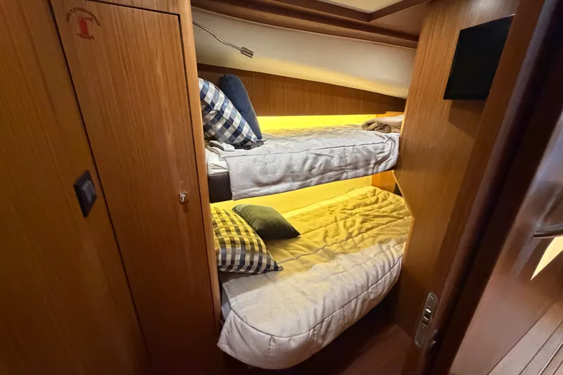 Slide: The Image of Bunk beds in 2017 Tiara Yachts 39 Convertible cabin with cozy pillows and wooden interior. - 55