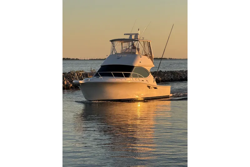 Slide: The Image of 2017 Tiara Yachts 39 Convertible cruising at sunset on calm waters. - 11